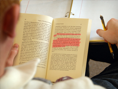 A student reading a book to study for a final exam