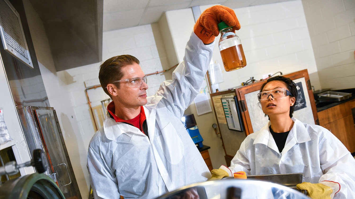 Faculty members don white coats and perform research in a lab on NC State's campus.