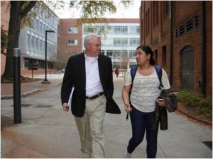 A student walking with Chancellor Woodson
